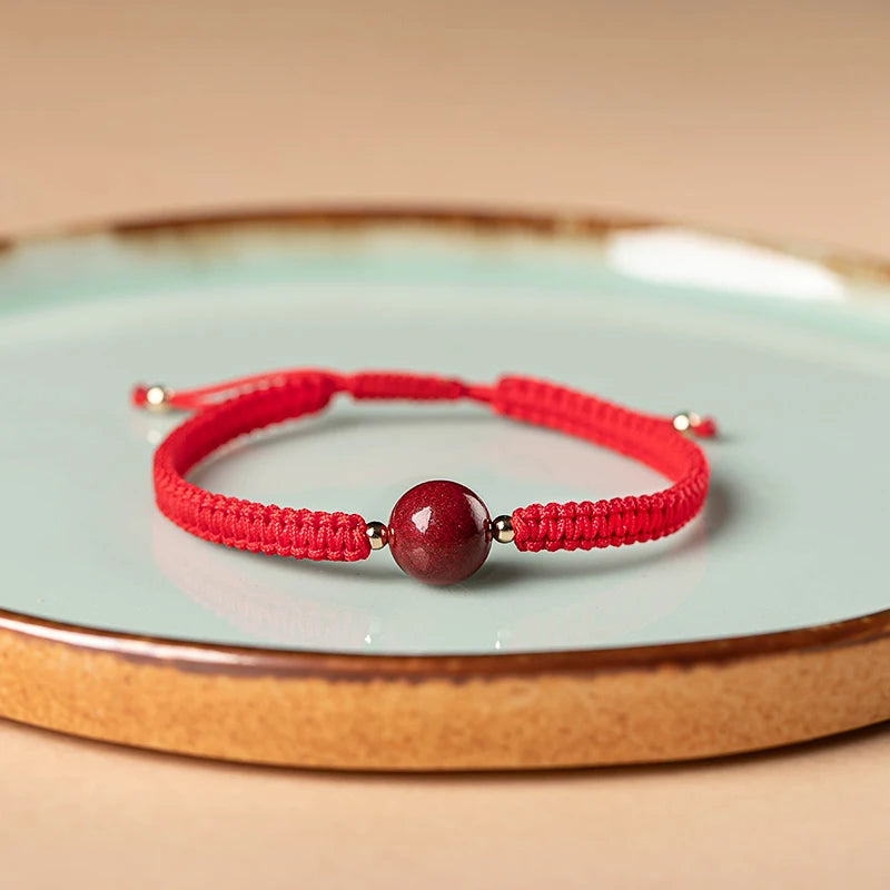 Pulsera roja trenzada con cuenta central