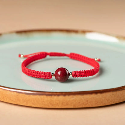 Pulsera roja trenzada con cuenta central