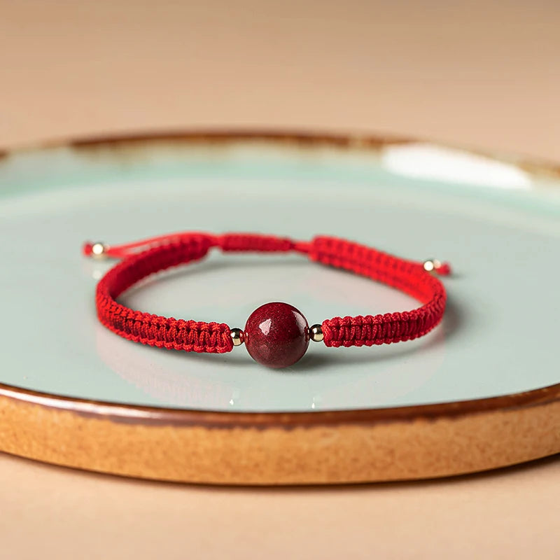 Pulsera roja trenzada con cuenta central