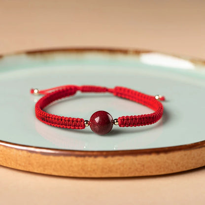 Pulsera roja trenzada con cuenta central