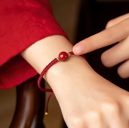 Pulsera roja trenzada con cuenta central