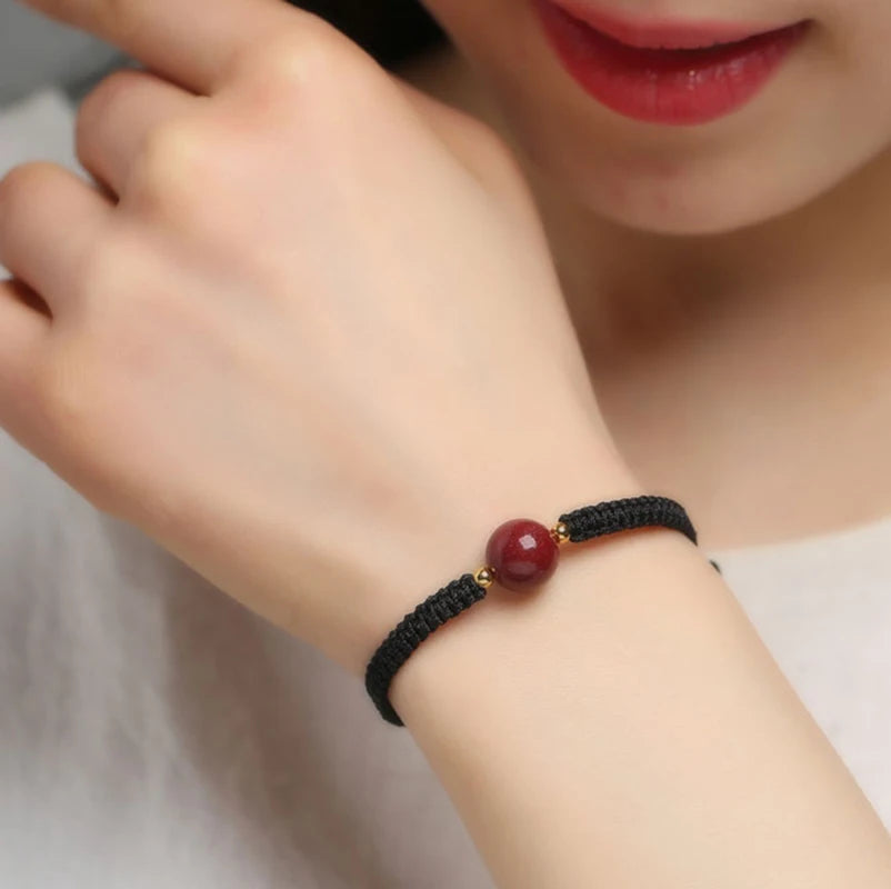 Pulsera roja trenzada con cuenta central