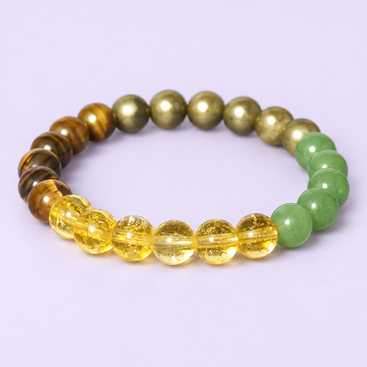 Pulsera Intención de cuentas redondas amarillas, verdes, marrones y de tono dorado sobre fondo lavanda.